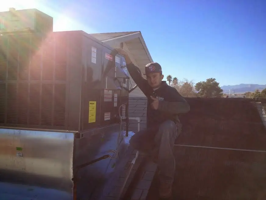 HVAC technician performing AC Tune-Up on a rooftop unit in Lindale